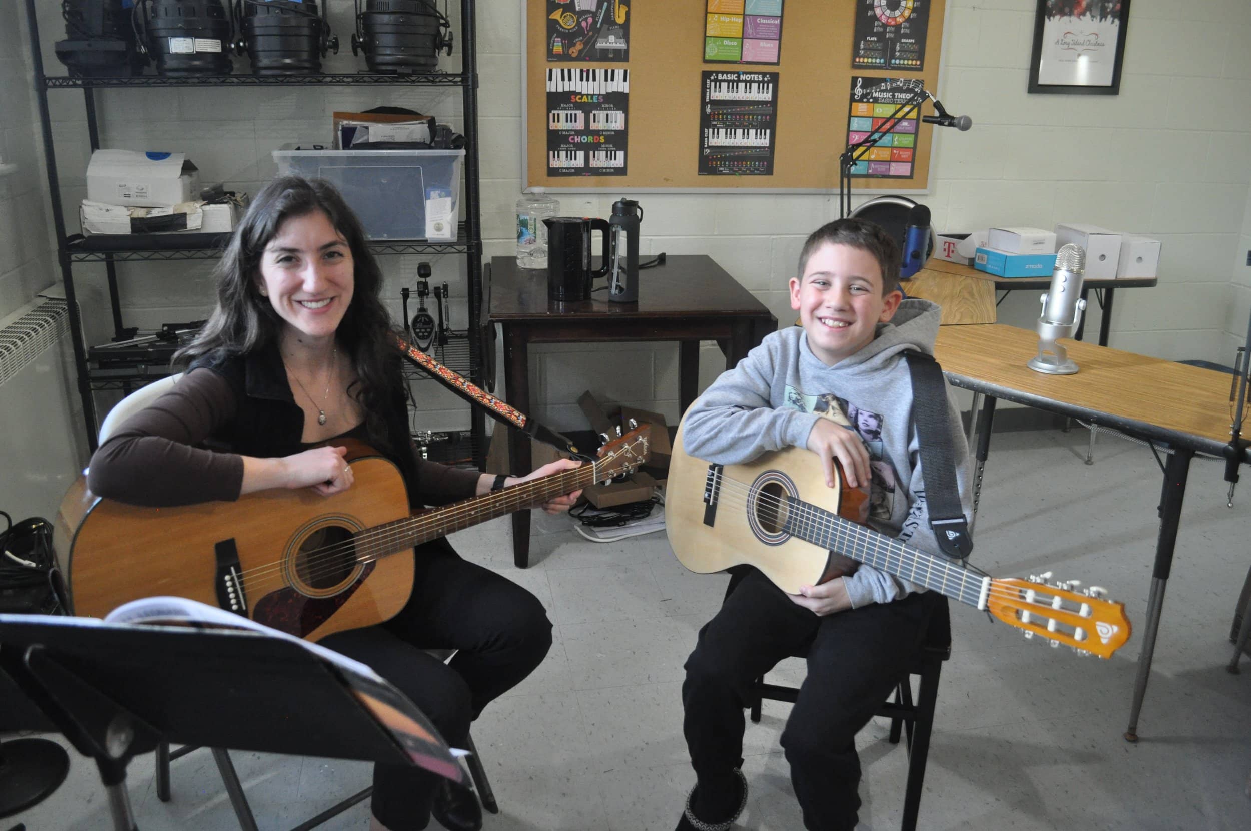 Guitar teacher and young student with acoustic guitars at Michael Mingoia Music school in Patchogue, NY