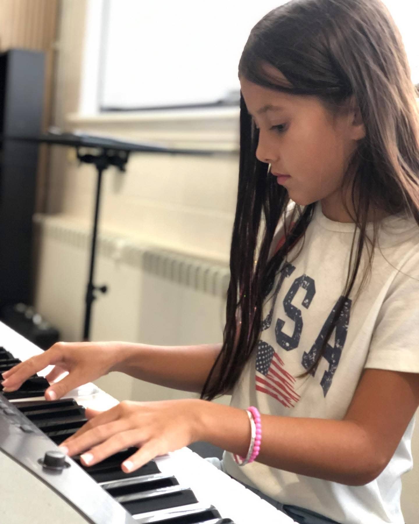 Student focused on playing keyboard at Michael Mingoia School of Music in Patchogue, NY
